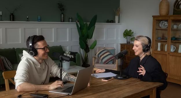 A man and a woman recording a podcast