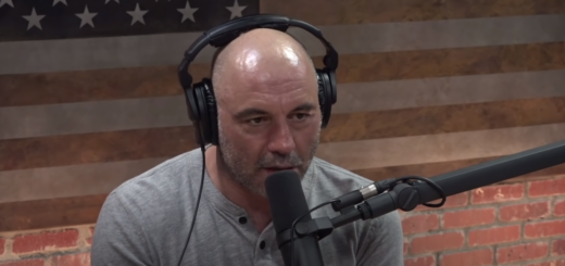 Joe Rogan in gray shirt, wearing headset, speaking into microphone