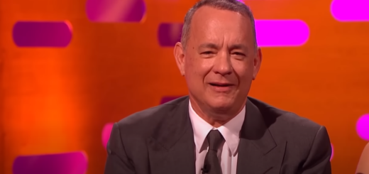 Tom Hanks in a suit against an orange background