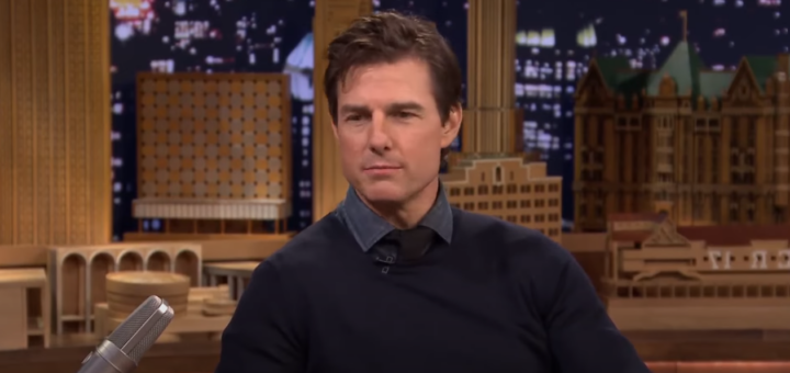 Tom Cruise during an interview with a backdrop of a building