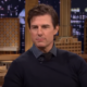 Tom Cruise during an interview with a backdrop of a building