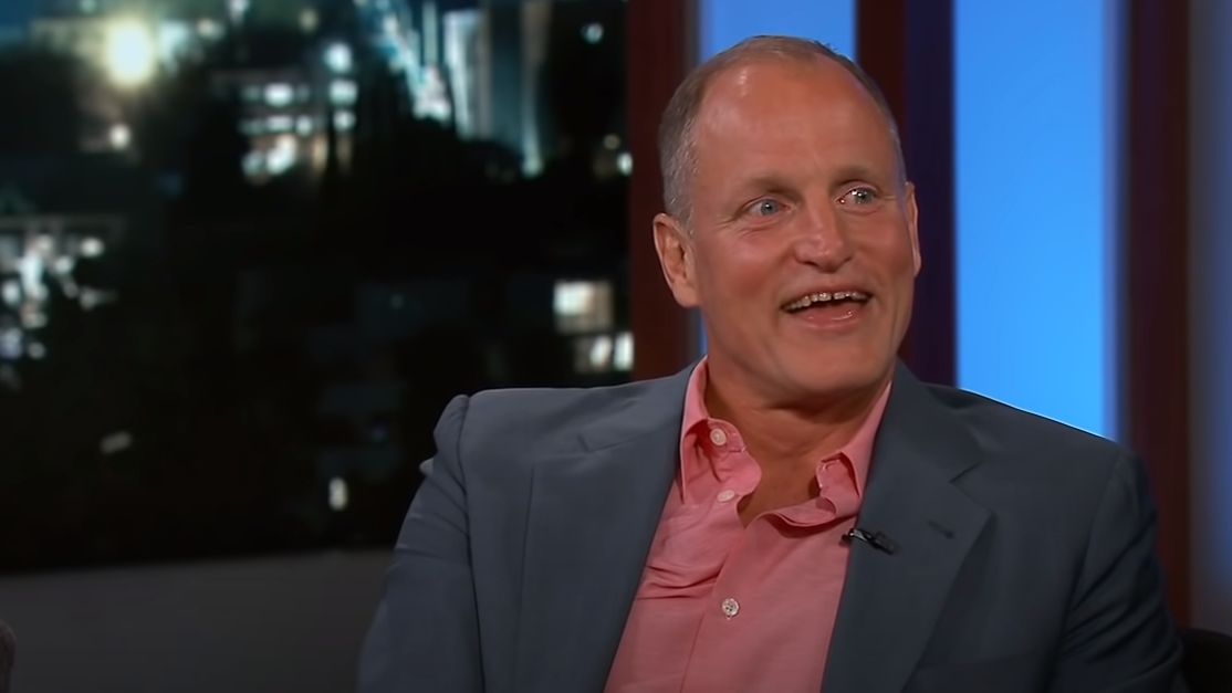 Picture of a smiling Woody Harrelson in a suit