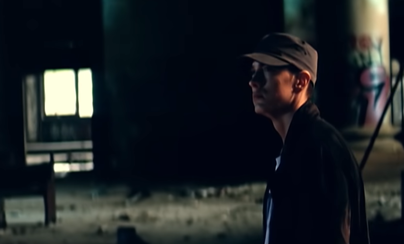 eminem in hat standing in abandoned building