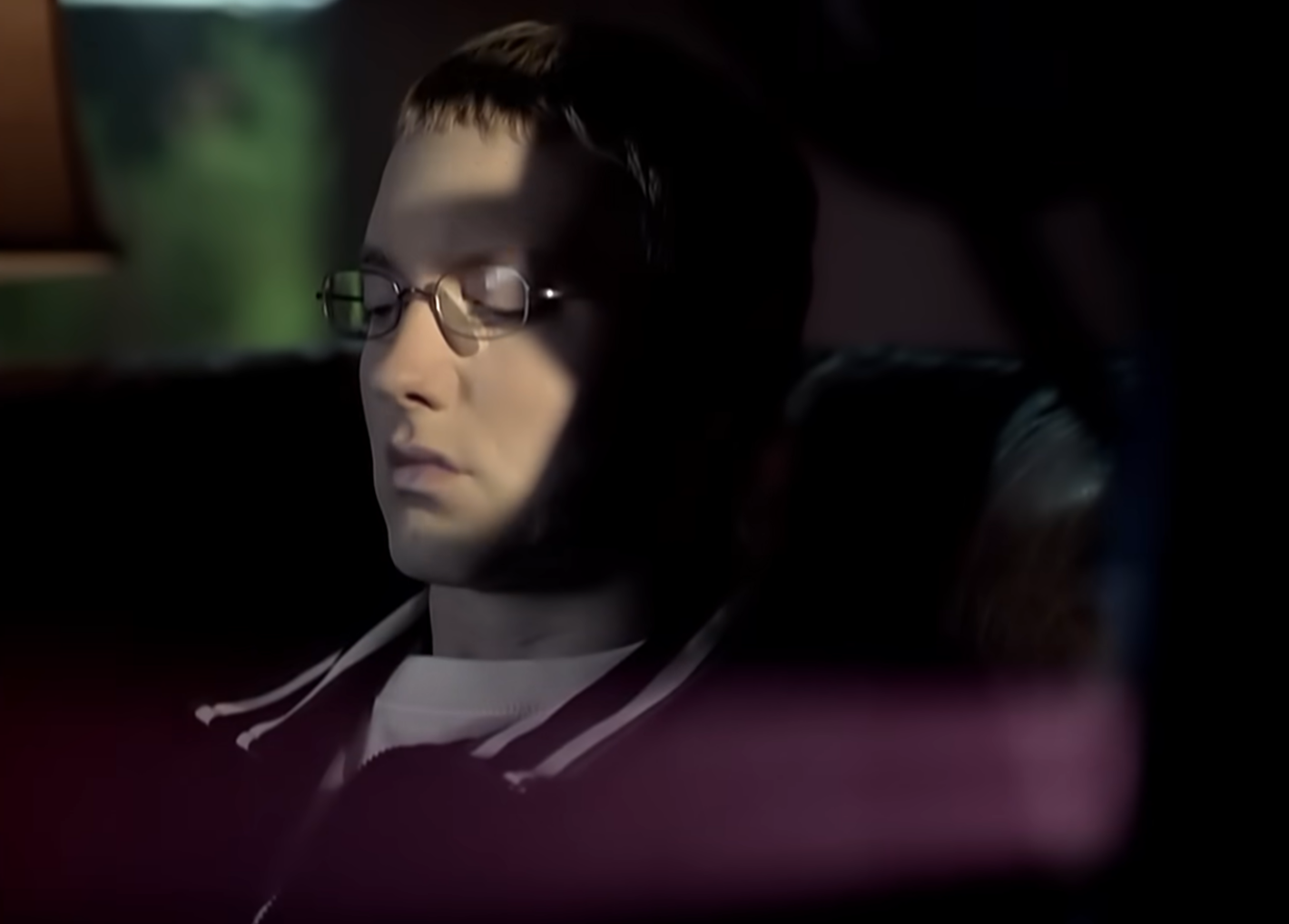 eminem in glasses sitting in a car