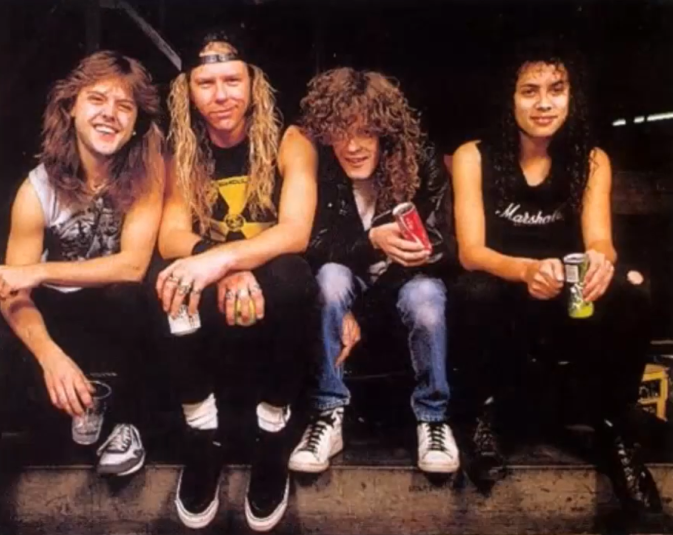 Metallica members holding the beverages and sitting on the stairs