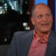 Picture of a smiling Woody Harrelson in a suit